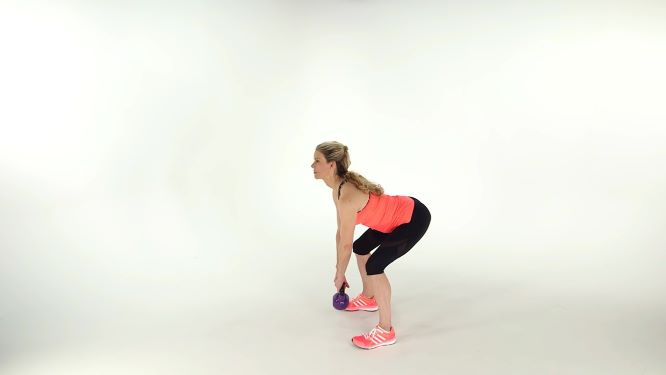 Woman swinging a kettlebell in down position